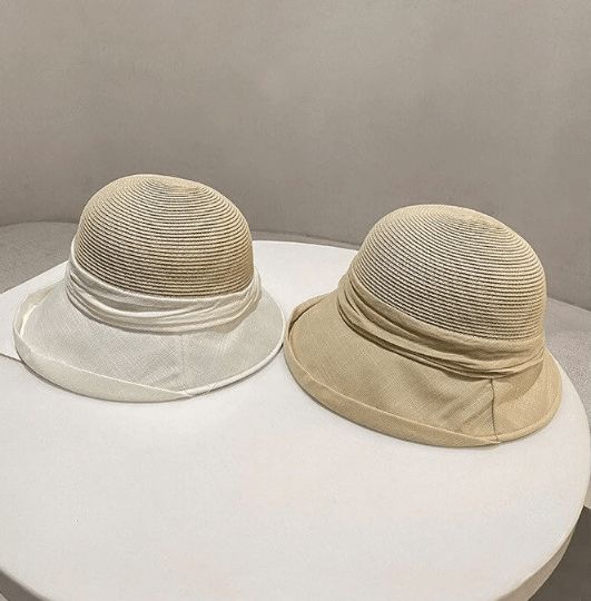 two hats sitting on top of a white table