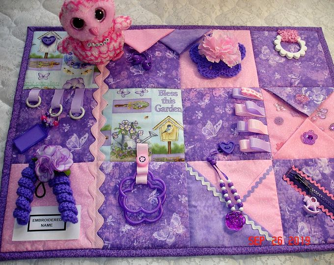 a purple and pink quilted place mat with various items on it