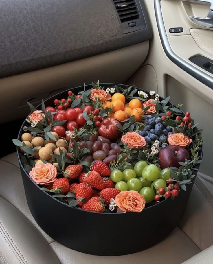 a car filled with lots of fruit and flowers on the dash board, next to a steering wheel