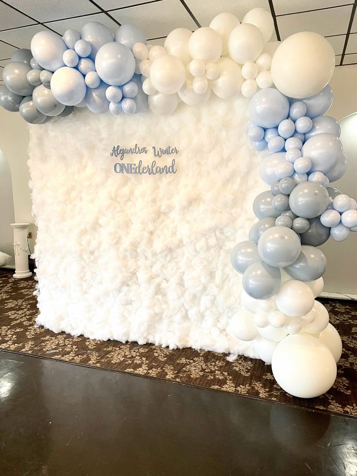 a backdrop made out of white and blue balloons