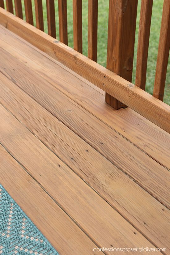 a close up of a wooden deck with grass in the background