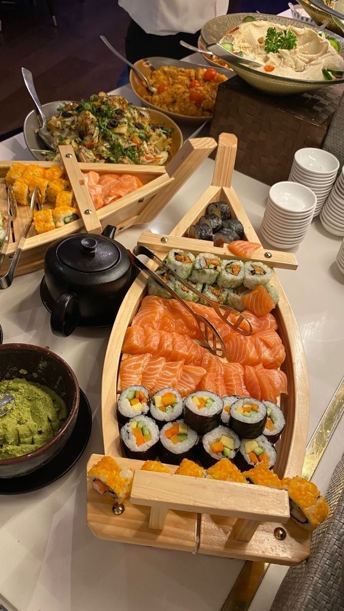 sushi platters are arranged on a buffet table