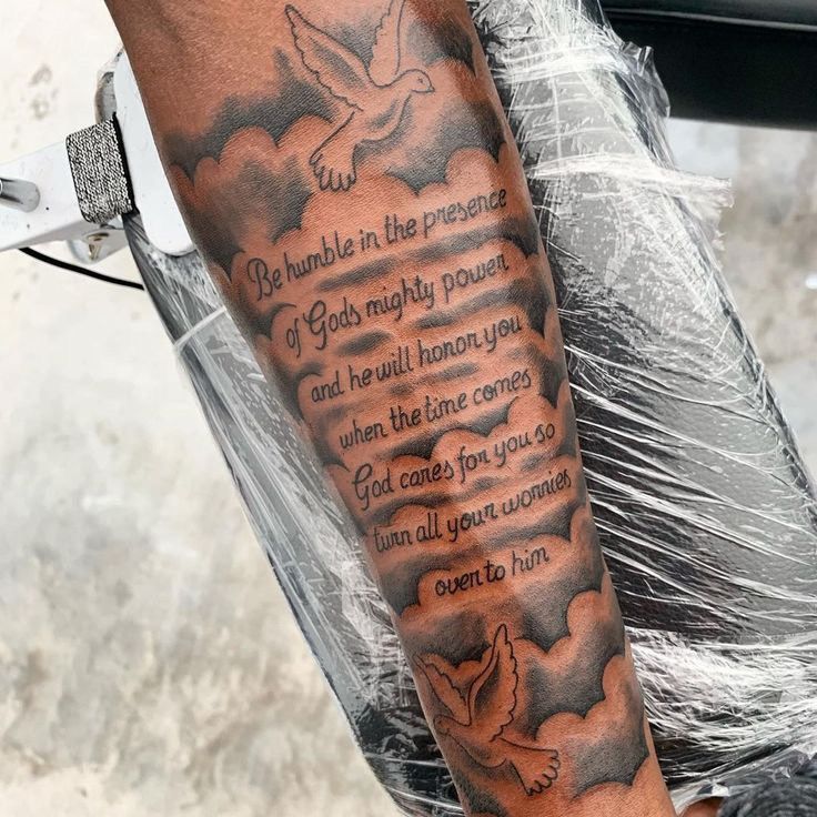 a man with a tattoo on his arm has a poem written in the clouds and doves