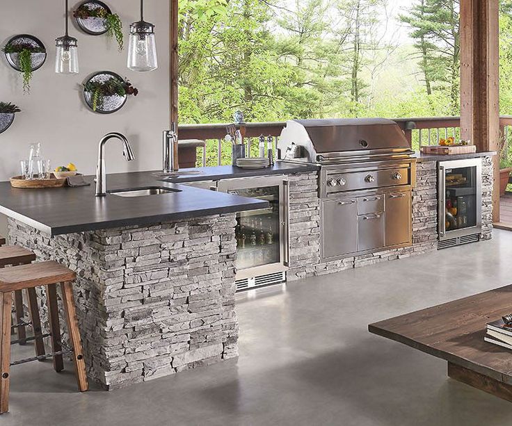 an outdoor kitchen with stainless steel appliances and counter tops