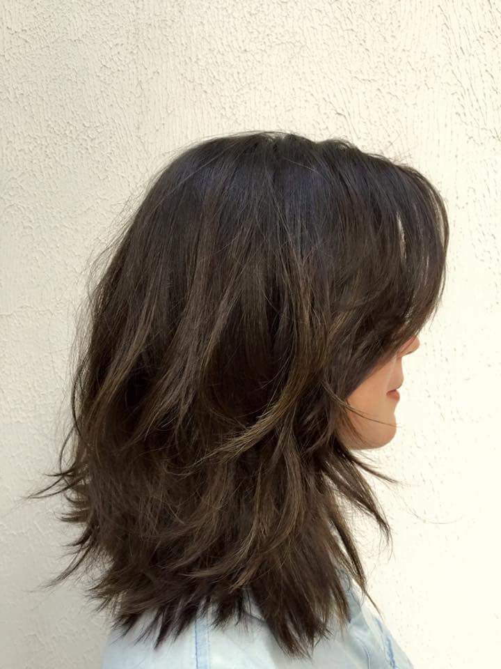 the back of a woman's head with long, dark brown hair and bangs