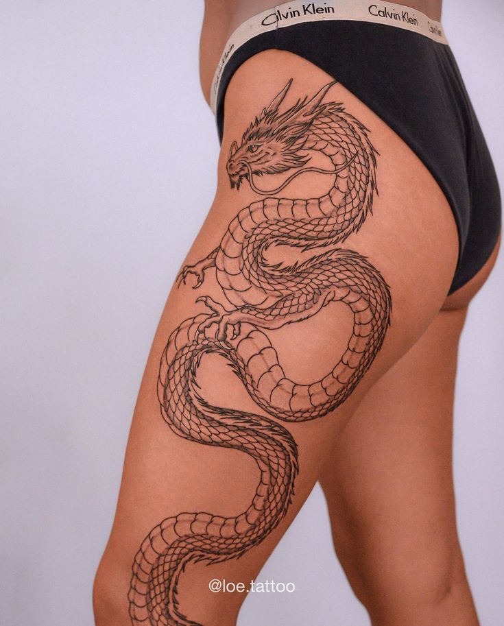 a woman's thigh with a tattoo on the side and a dragon on it