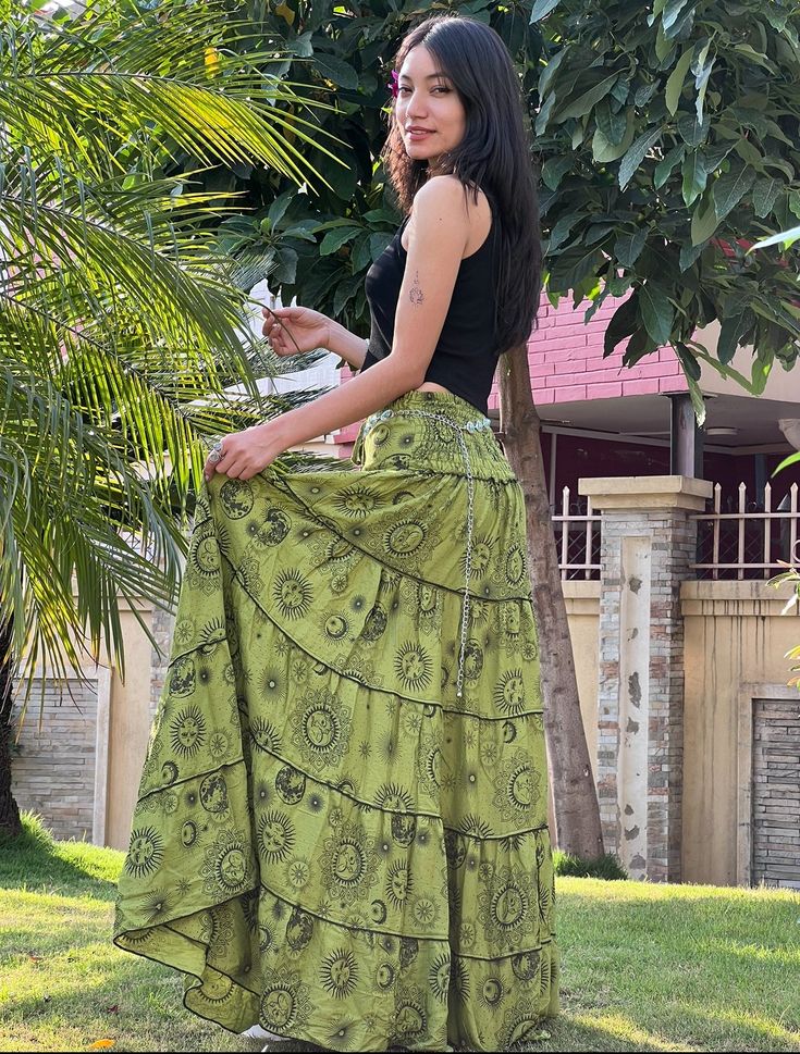 Introducing the Akasiya Maxi Skirt, a celestial-inspired masterpiece that blends style and versatility effortlessly. Crafted with a celestial print that evokes a sense of wonder, this skirt is adorned with a smocked back and a drawstring closure, ensuring a flattering and adjustable fit. Practicality meets chic with the addition of pockets, perfect for keeping essentials close at hand while maintaining a seamless look. Whether paired with a simple top for a casual outing or dressed up with a blo Green Bohemian Long Wrap Skirt, Bohemian Green Long Wrap Skirt, Bohemian Green Wrap Skirt For Festival, Green Tiered Skirt For Festival, Green Bohemian Gathered Skirt, Green Bohemian Long Skirt, Green Bohemian Flowy Skirt, Bohemian Green Gathered Skirt, Green Flowy Bohemian Skirt