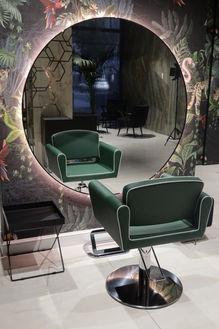 a chair and ottoman in front of a wall with a circular mirror on the wall