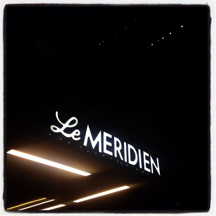 the sign for le meridien is lit up at night