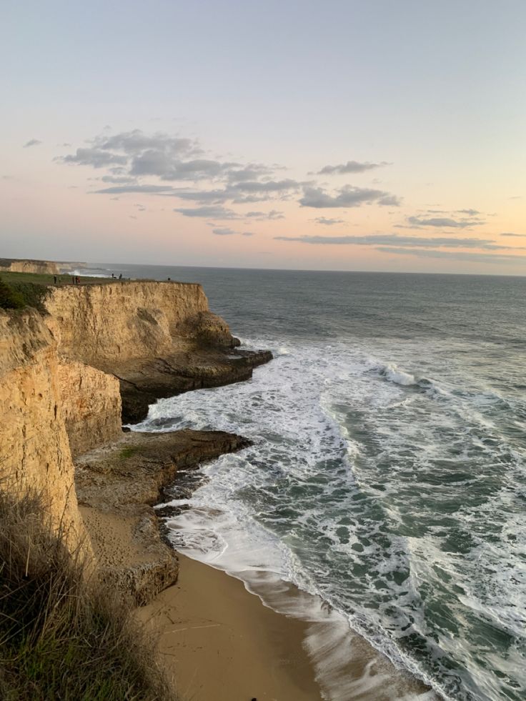 the beach is next to an ocean cliff