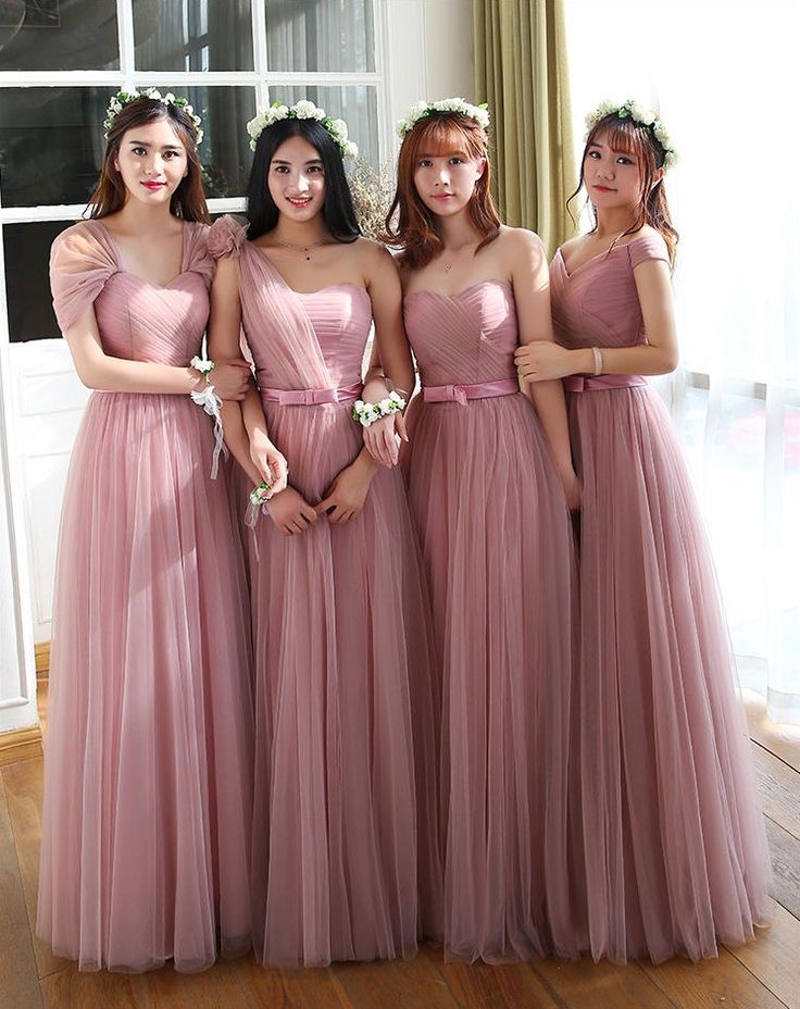 four women in pink dresses posing for the camera with their hands on their hipss