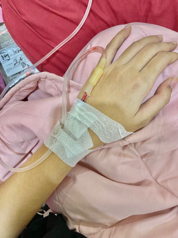 a person in a hospital bed with an iv tube wrapped around their arm and hand