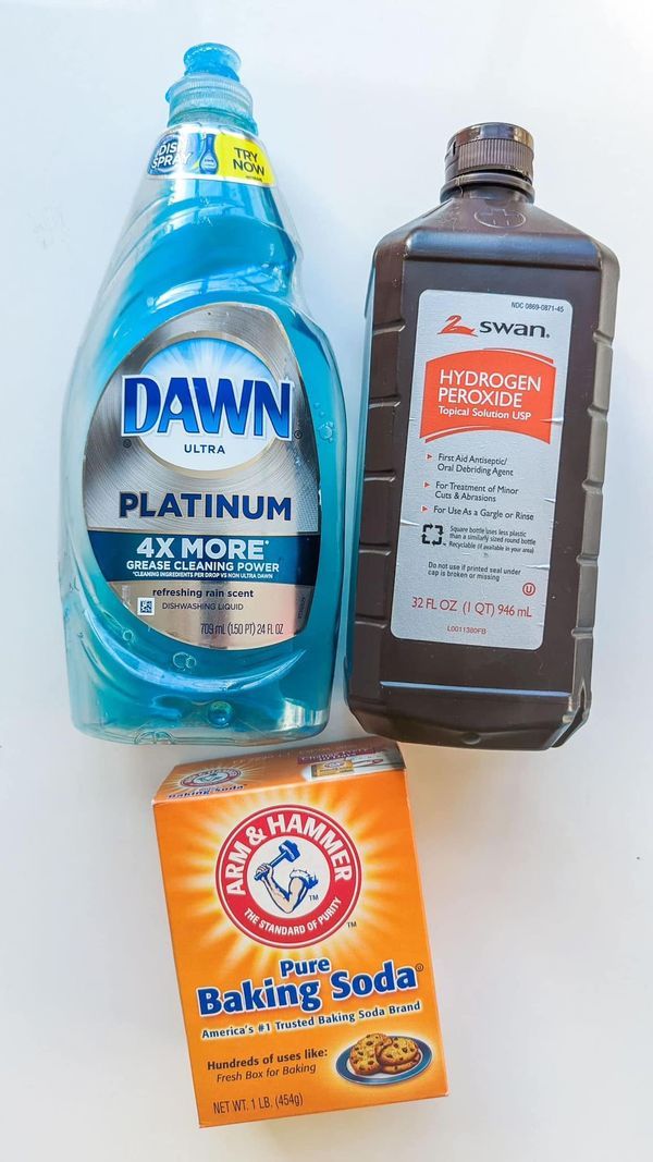 the contents of a dishwasher sitting next to a bottle of detergent and a packet of baking soda