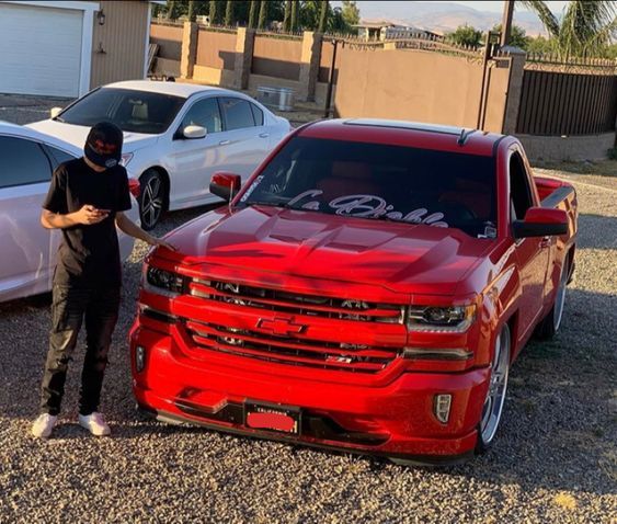 a man standing next to a red truck