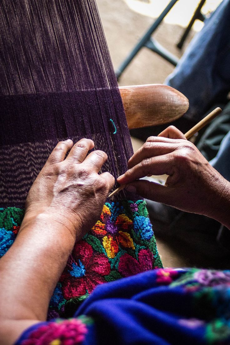 an old woman is weaving fabric with her hands