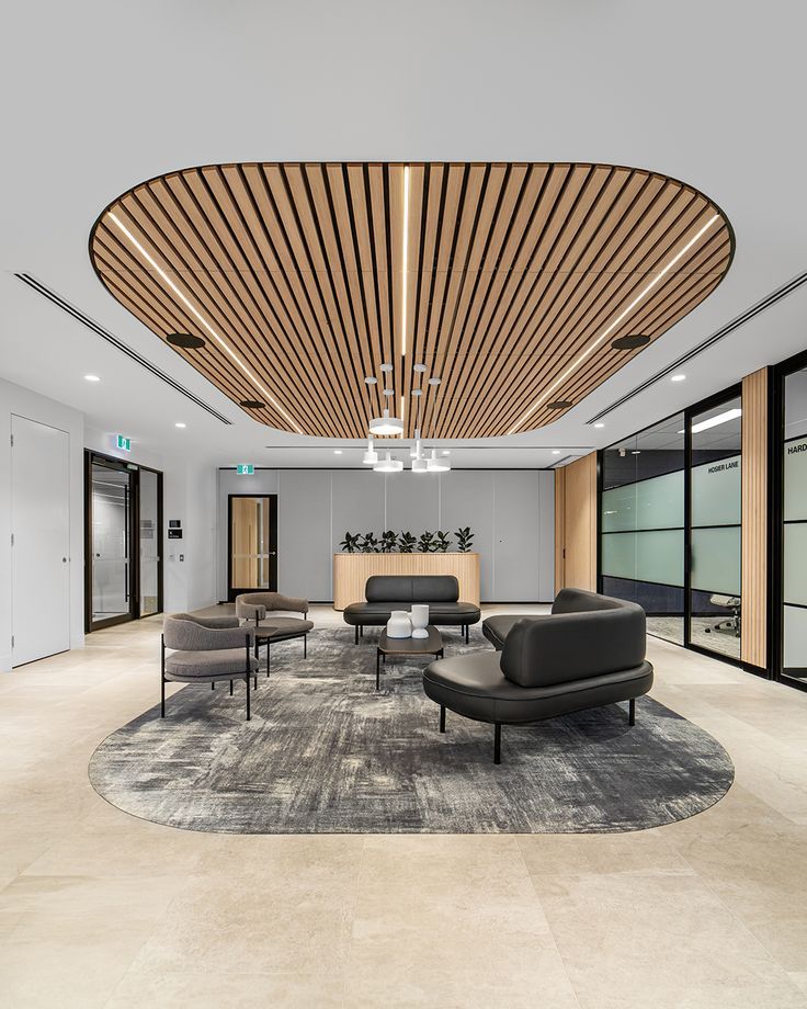 an office lobby with couches, chairs and tables in the middle of the room