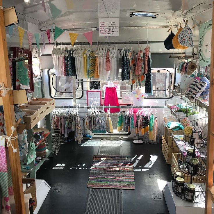 the inside of a small clothing store with lots of items