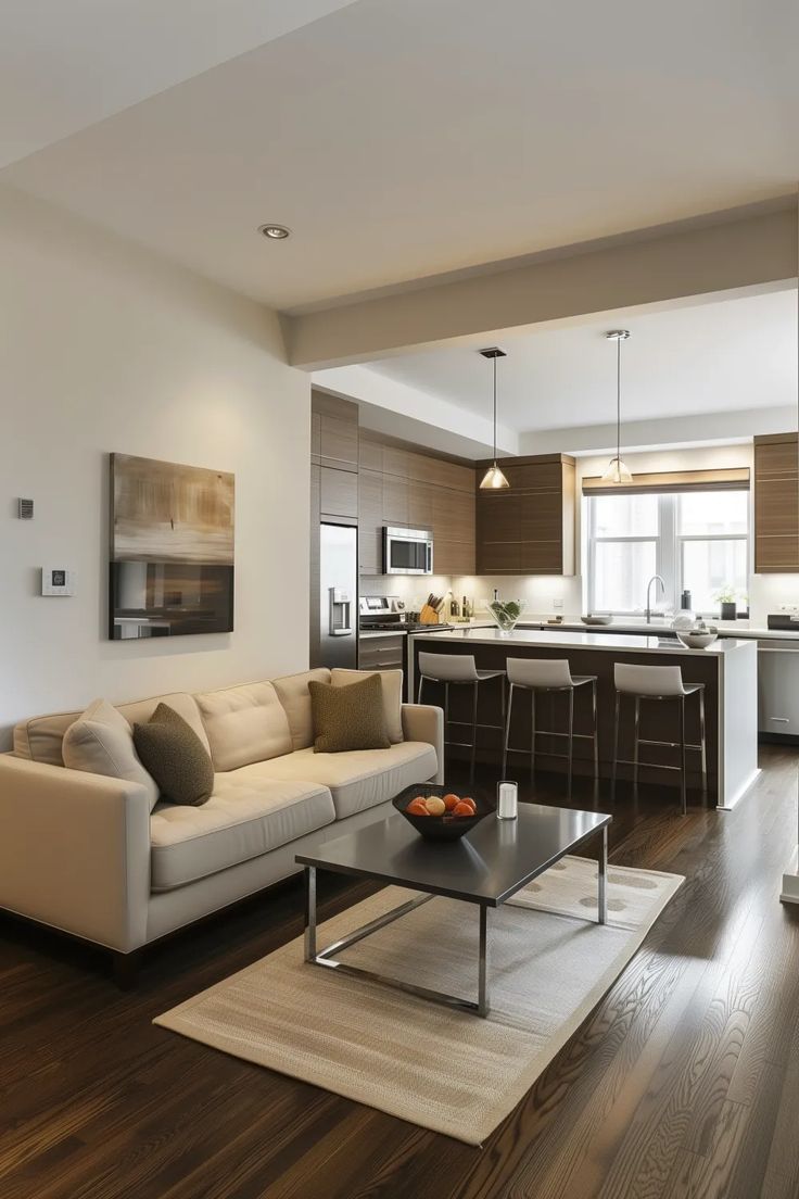 a living room filled with furniture and a kitchen in the backgroung area