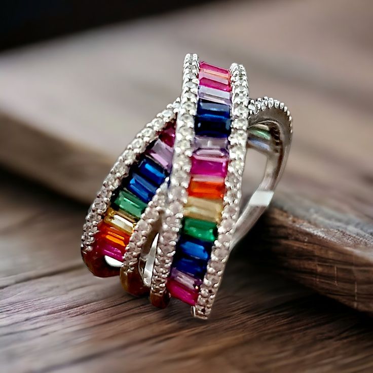 Beautiful In Meaning And Appearance, Rainbows Hold A Special Place In Many Hearts. Crafted In Sterling Silver, This Ring Boasts A Stunning X Crossover Design That Is Lined With Baguette-Shaped Cubic Zirconia Stones In A Rainbow Of Vibrant Colors. The Rainbow Rows Are Bordered On Each Side With Round, Clear Cubic Zirconia Stones For Added Sparkle And Shine. This Ring Measures 14mm Across The Top And 7mm Across The Bottom. Specifications Ring Width: 14 To 7 Mm Metal: 925 Sterling Silver Stone Type Macy's Luxury Rings As A Gift, Macy's Luxury Rings As Gifts, Luxury Macy's Rings As Gifts, Multicolor Baguette Cut Ring For Anniversary, Multicolor Cubic Zirconia Party Rings, Macy's Cubic Zirconia Rings For Gift, Multicolor Rings With Sparkling Stones For Gift, Multicolor Gemstone Rings With Baguette Cut, Dazzling Multicolor Cubic Zirconia Rings