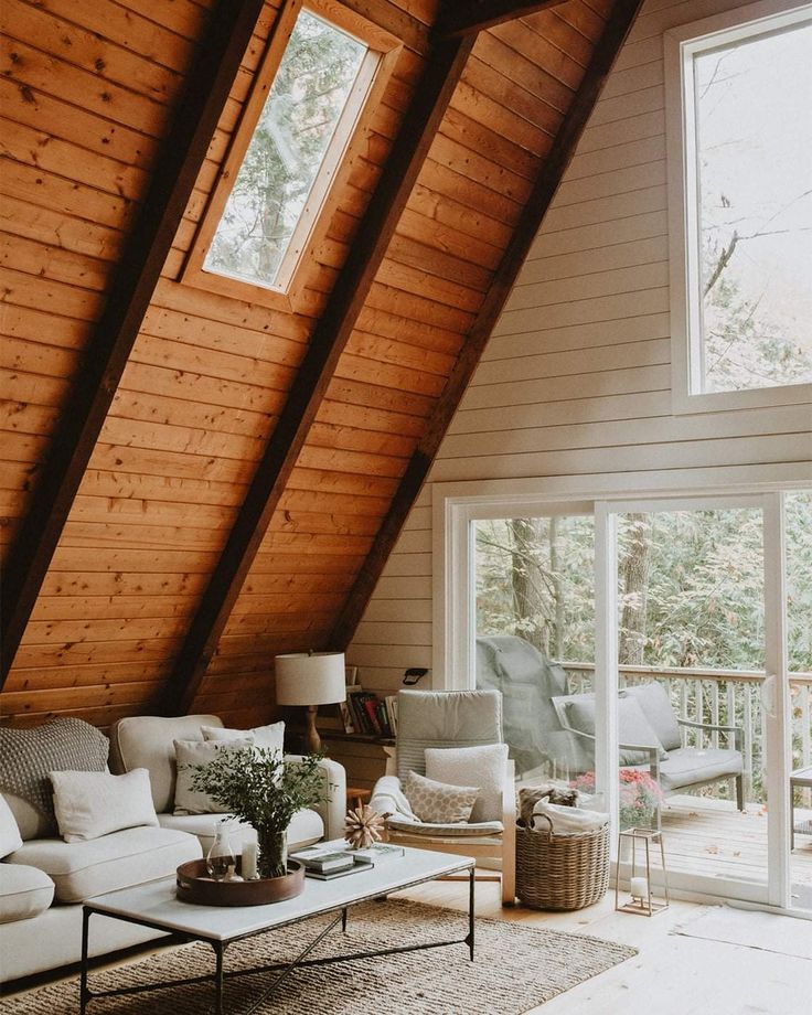 a living room filled with furniture and lots of wooden walls on top of a roof