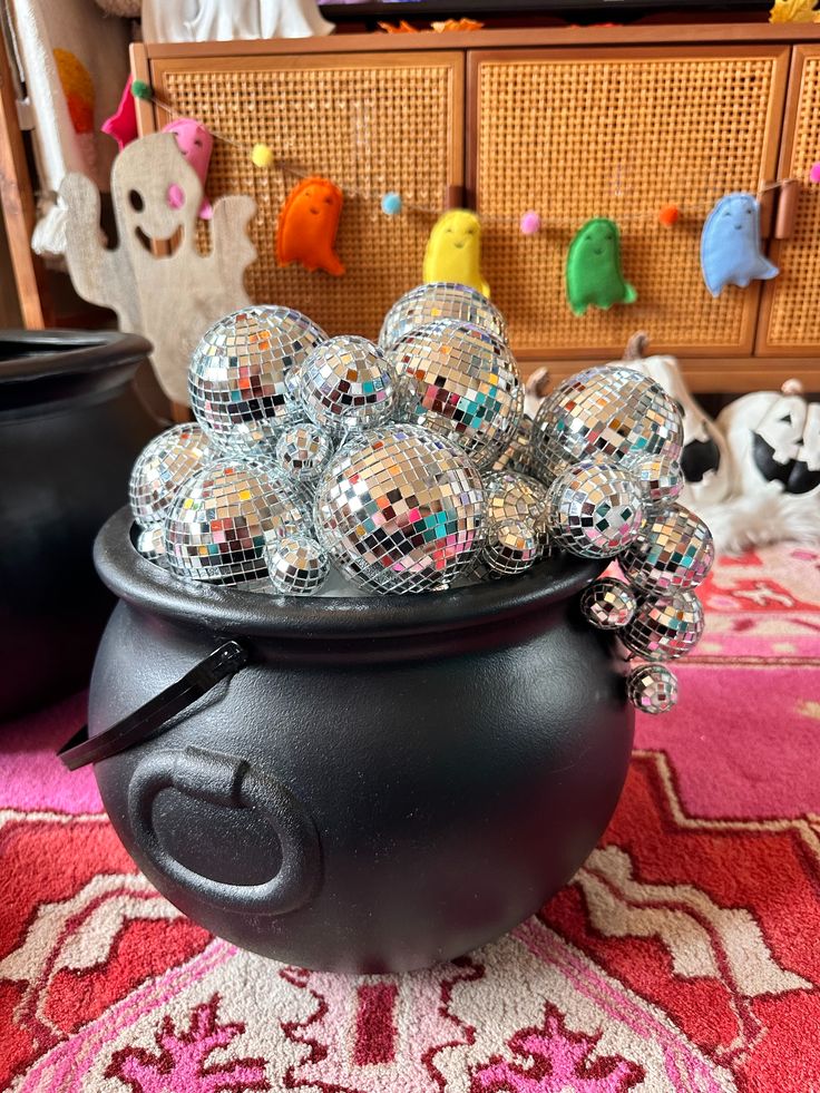 a black pot filled with lots of shiny balls