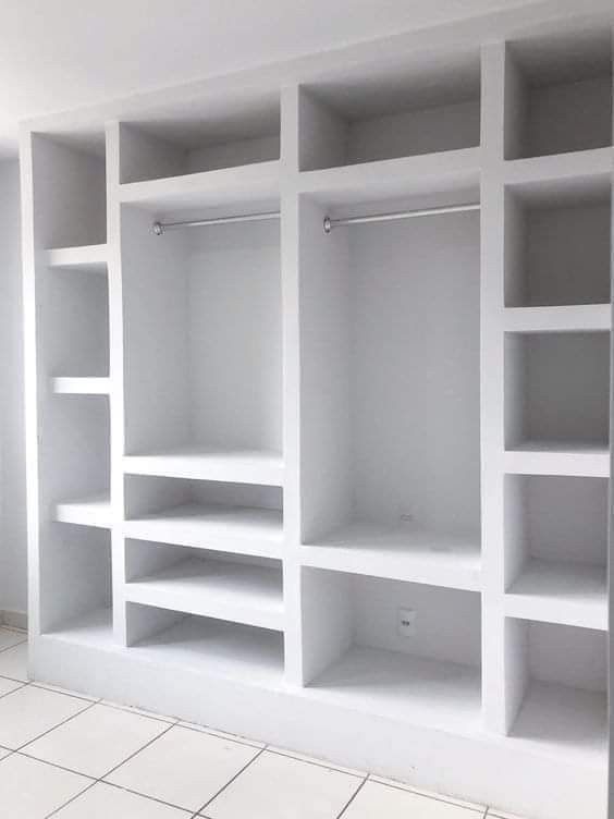 an empty room with white shelving and tile flooring in the middle of it