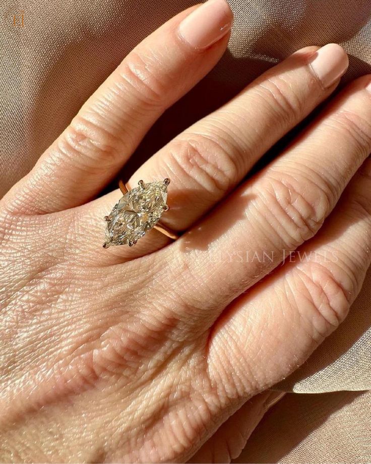 a woman's hand with a diamond ring on it