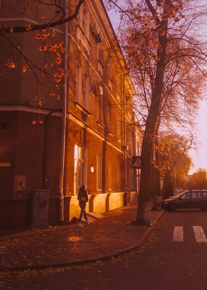 a person walking down the street in front of a building