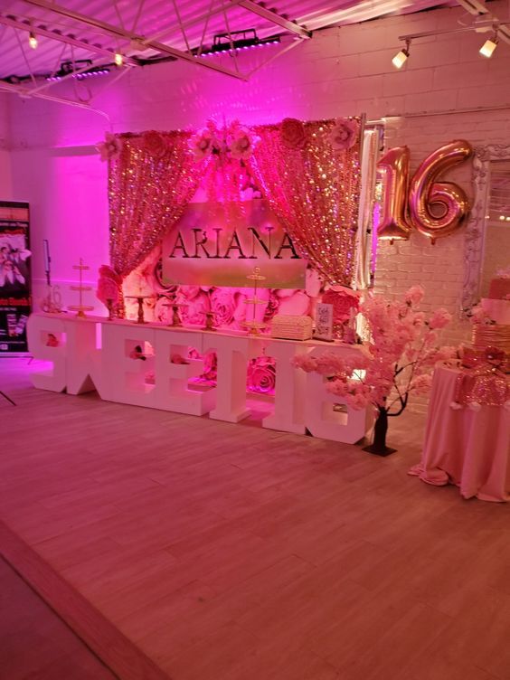 a pink and gold birthday party with balloons, cake and decorations on the dance floor