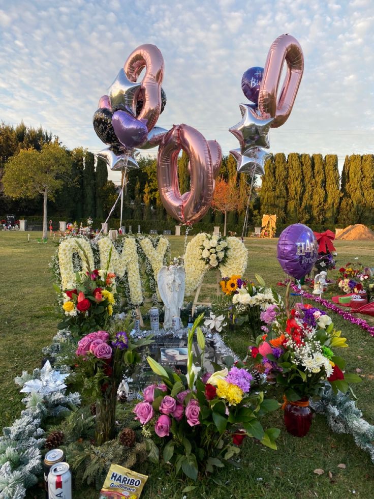 flowers and balloons are placed in the grass