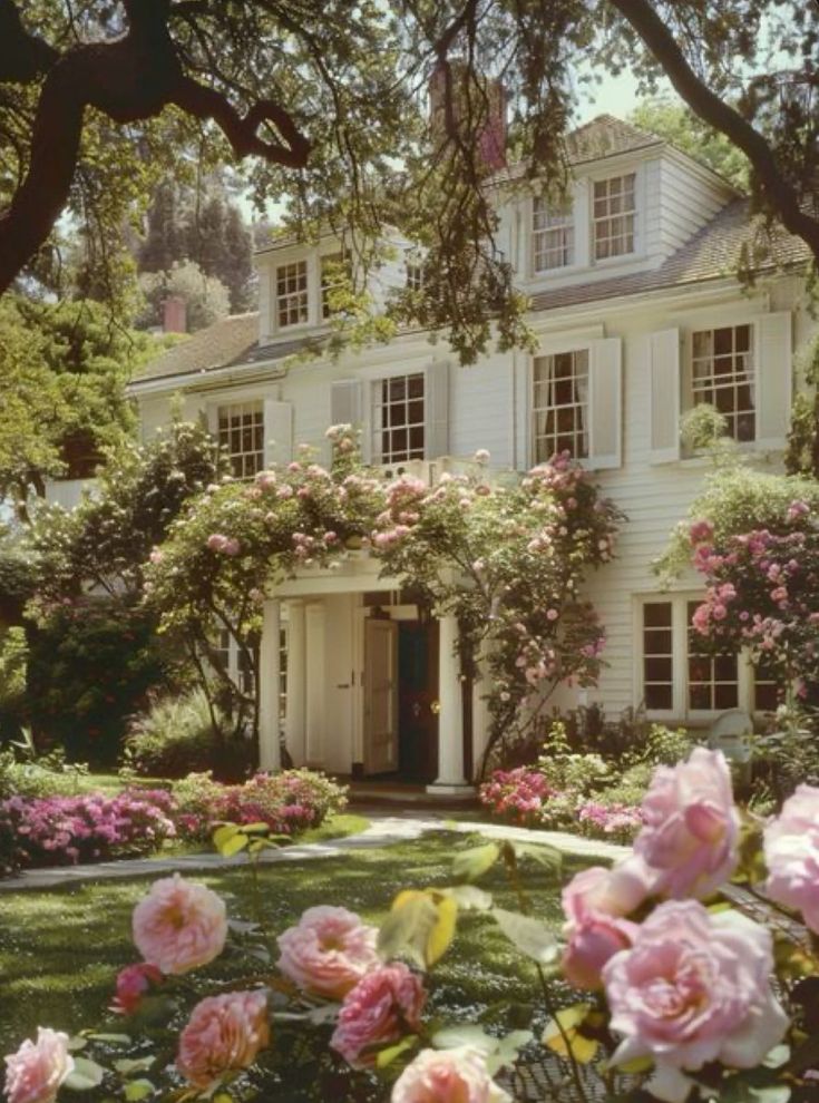 a large white house surrounded by pink flowers