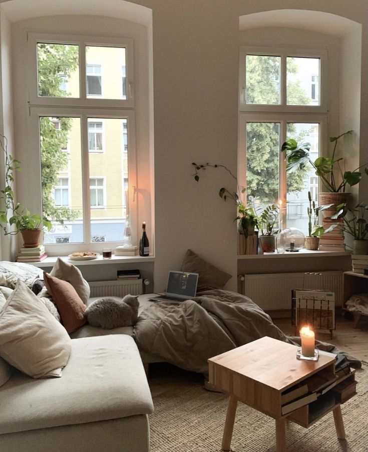 a living room filled with lots of furniture next to two windows and a coffee table