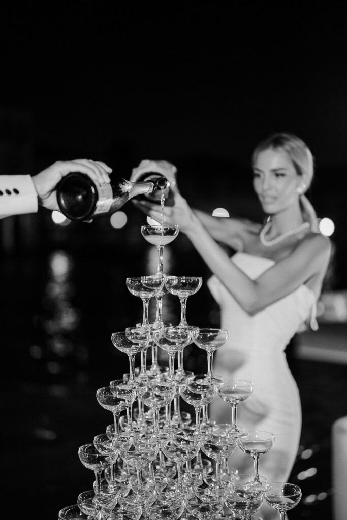 a man and woman are pouring champagne into wine goblets at a wedding reception