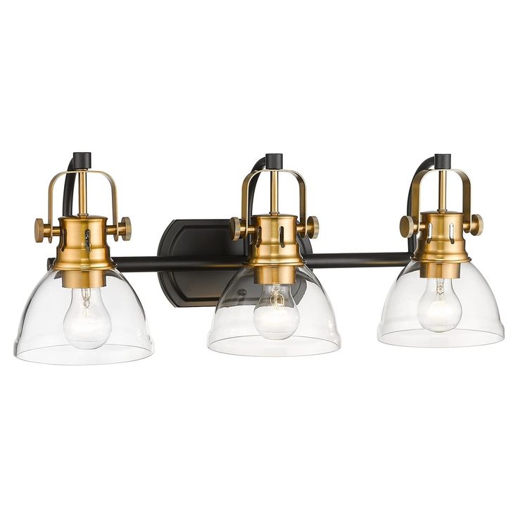 three light bathroom fixture in an antique brass finish with clear glass shades on the bulbs