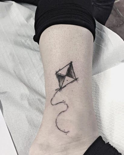 a small kite tattoo on the ankle