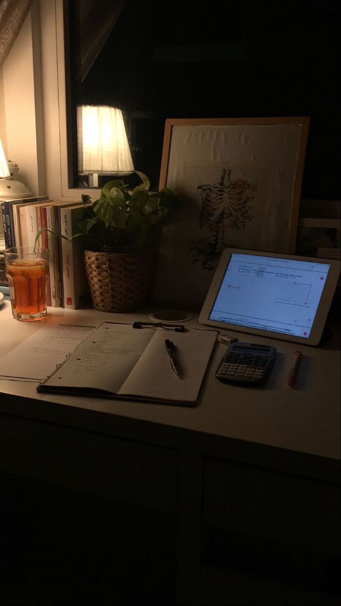 a laptop computer sitting on top of a desk next to a lamp and other items