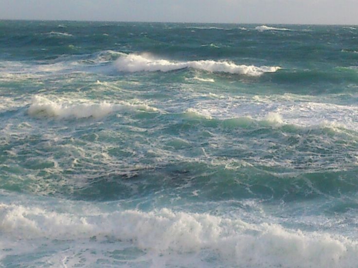 a man riding a surfboard on top of a wave in the ocean