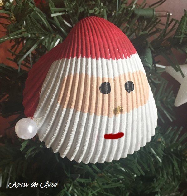 a christmas ornament hanging from a tree with a santa clause on it's face