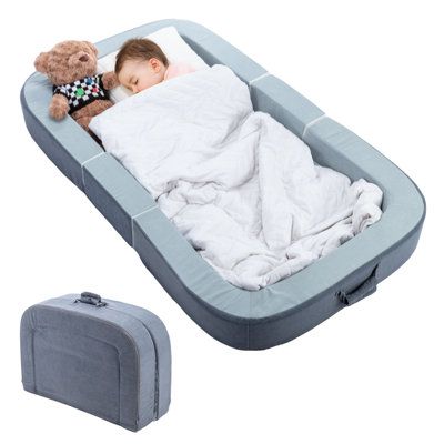 a baby sleeping in an inflatable bed with a teddy bear