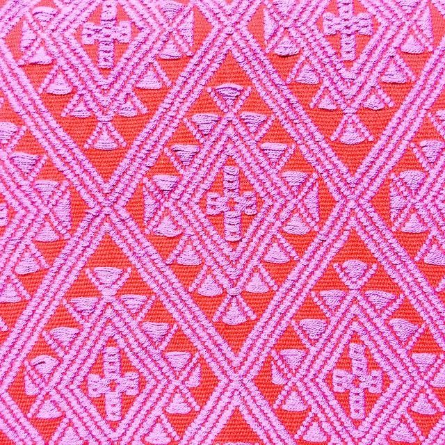 an orange and pink pattern on fabric