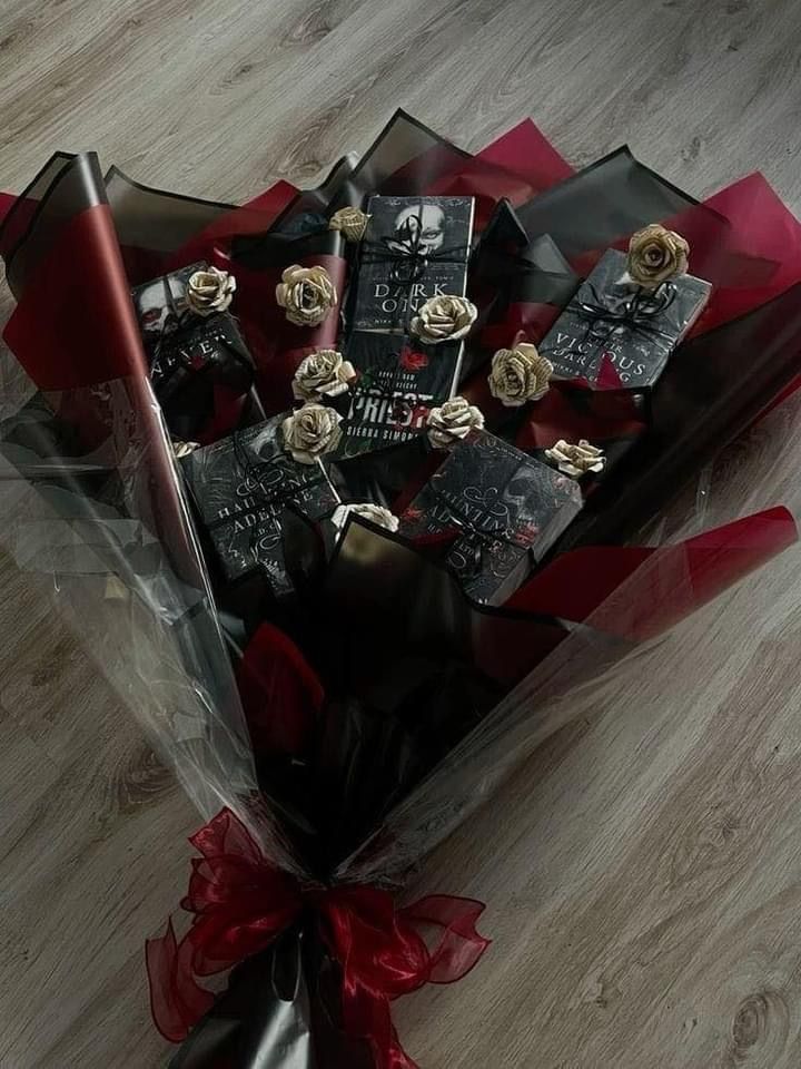 a bouquet of roses and chocolates wrapped in clear cellophane on the floor