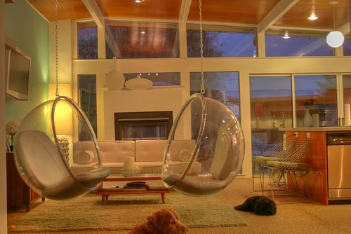 a living room filled with furniture and a cat laying on the floor next to it