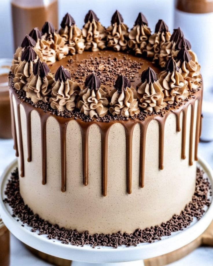 a cake with chocolate frosting and sprinkles sitting on a white plate