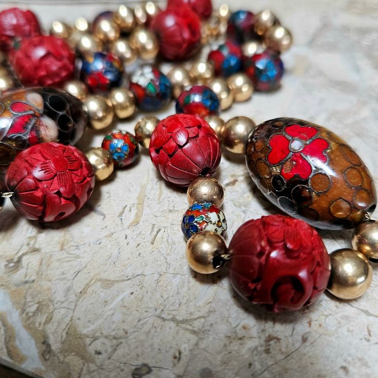 Light your fire this winter with this beautiful 28 inch 14 kt gold cinnabar and cloissone beaded necklace.  It has a marked 14 kt spring clasp w 48 gold beads, 7 round cinnabar beads, 12round cloisonne beads and 2 oval cloisonne beads on a gold chain.  Some of the gold beads are dented leading me to believe they are high quality gold as well.  Note the pictures.  A very classy necklace... This necklace is in stock and ready to ship immediately. Artisan Red Jewelry With Colorful Beads, Red Artisan Jewelry With Colorful Beads, Artisan Red Jewelry For Collectors, Artisan Red Collectible Necklaces, Artisan Red Collectible Jewelry, Vintage Red One-of-a-kind Jewelry, Artisan Red Necklaces With Spacer Beads, Handmade Round Beads Jewelry For Collectors, Handmade Round Beads Jewelry As Collectibles