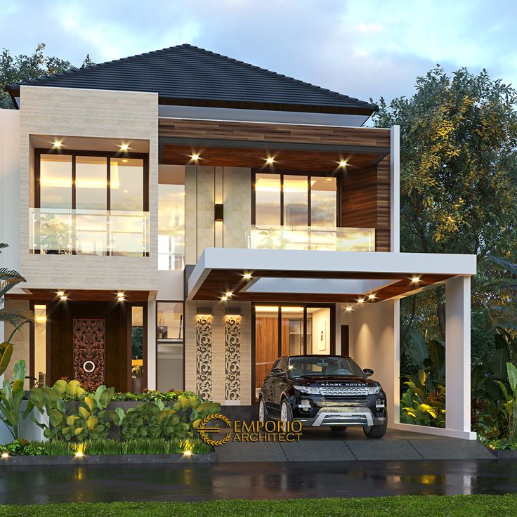 a car is parked in front of a two story house with lights on the windows