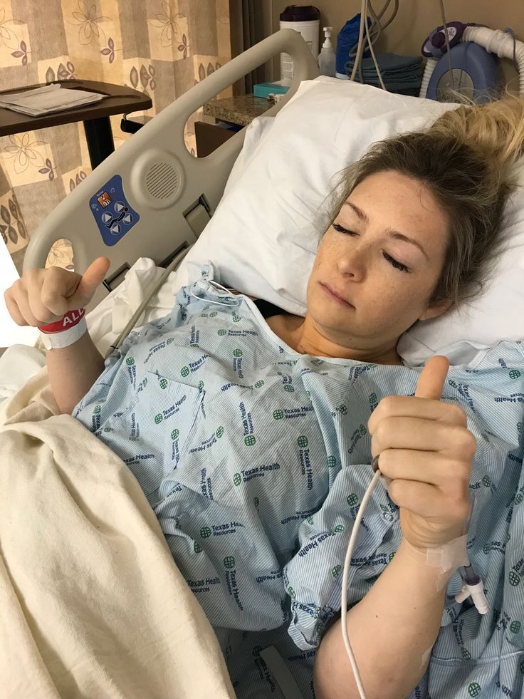 a woman laying in a hospital bed with an iv