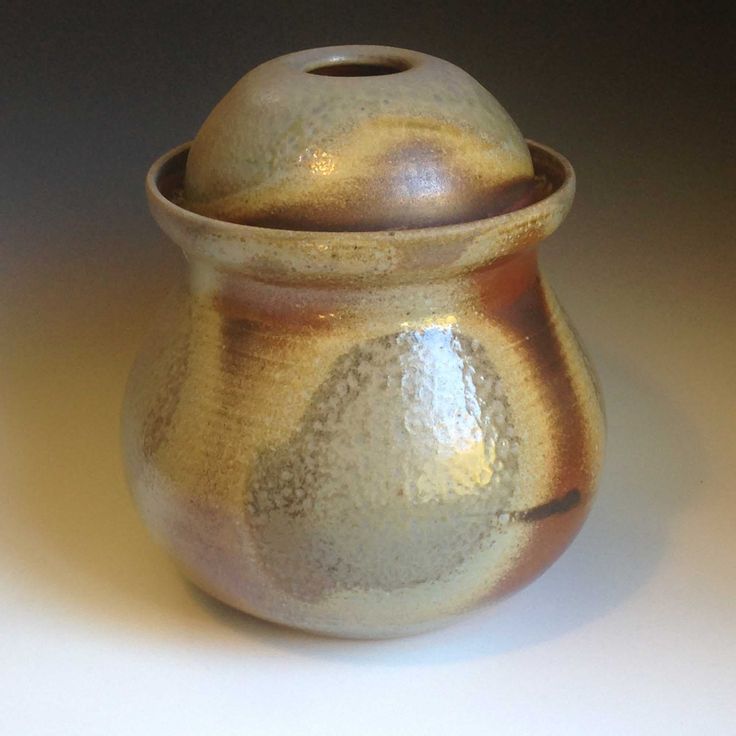 a brown vase sitting on top of a white table