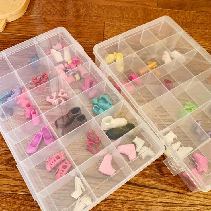 two plastic containers filled with lots of different types of toy items on top of a wooden table