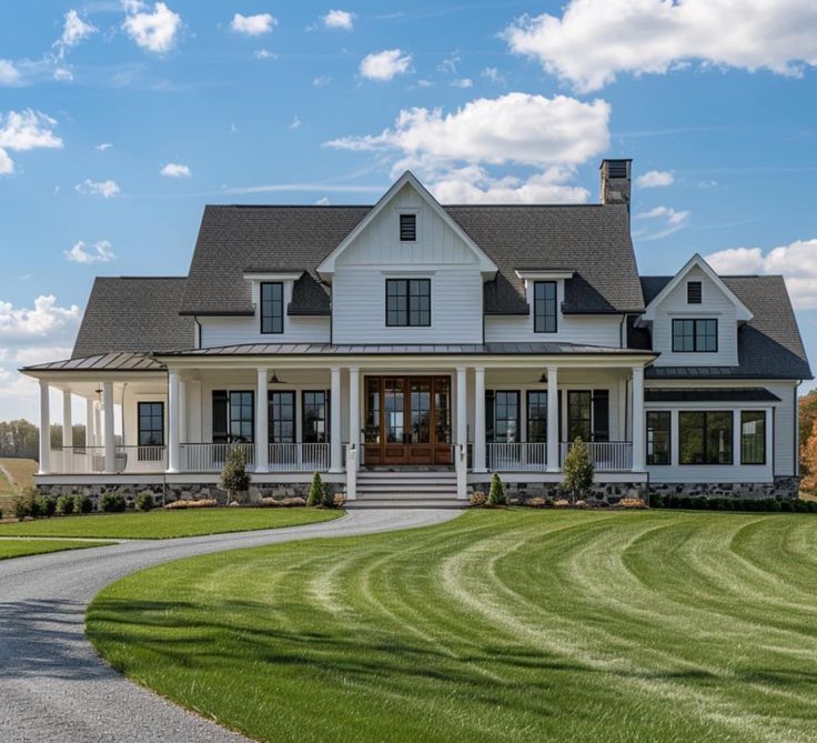 a large white house sitting on top of a lush green field