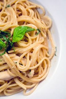 a white plate topped with pasta and sauce covered in parsley on top of it